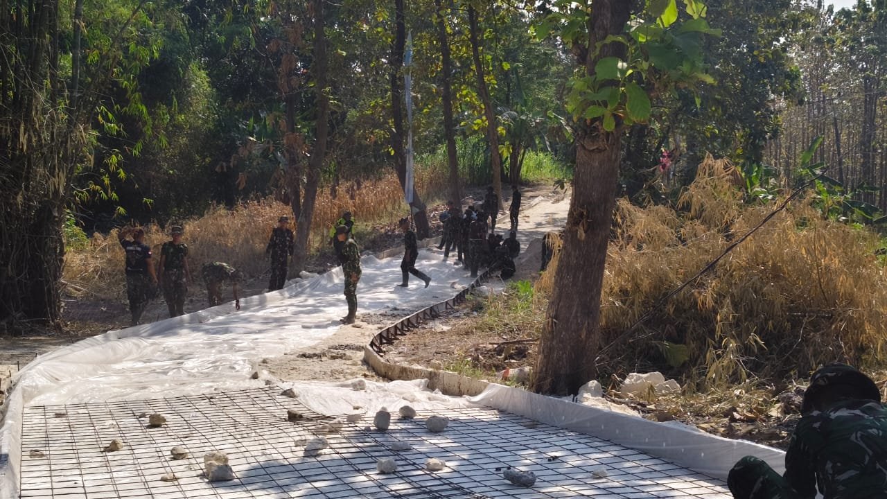 Kompak Bentangkan Plastik Alas Cor, Satgas TMMD dan Warga Perkuat Pondasi Jalan Rabat Beton Desa Tlemang