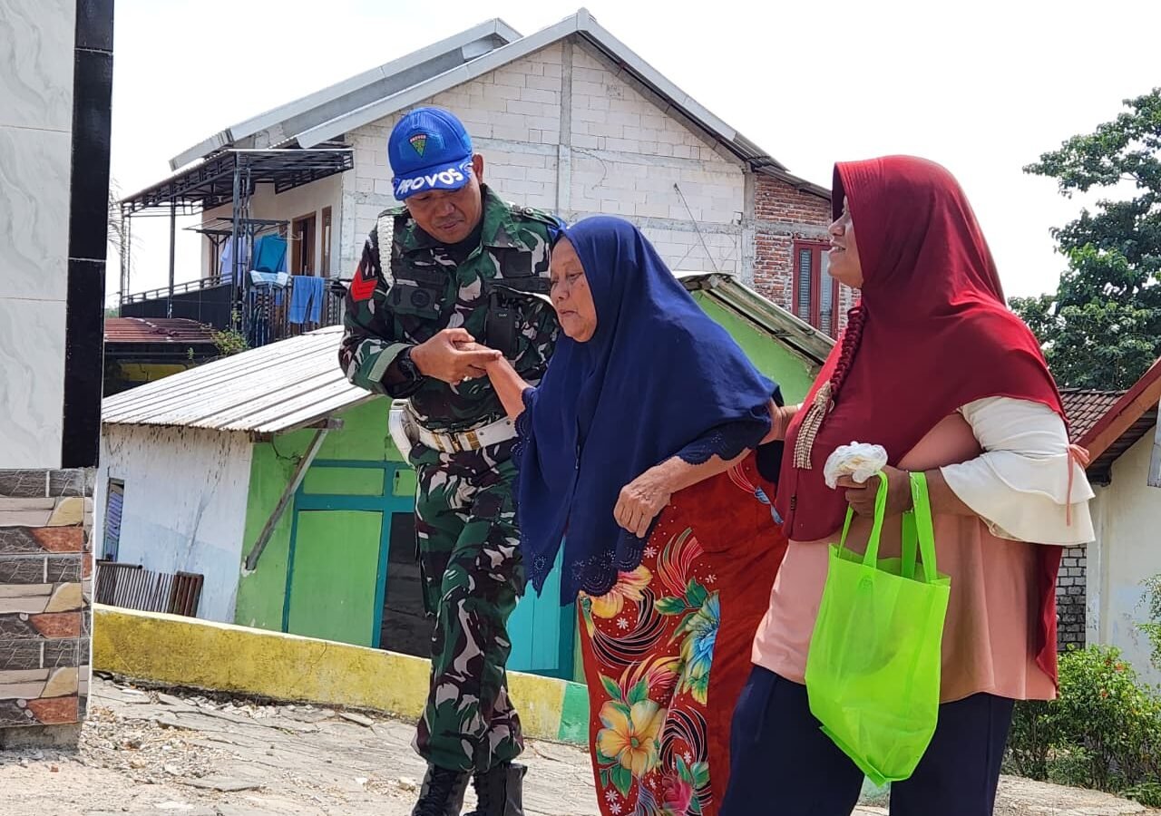 Kemanusiaan TNI Dalam TMMD 129: Kopka Eko Membimbing Lansia Menuju Posko Kesehatan di Desa Tlemang