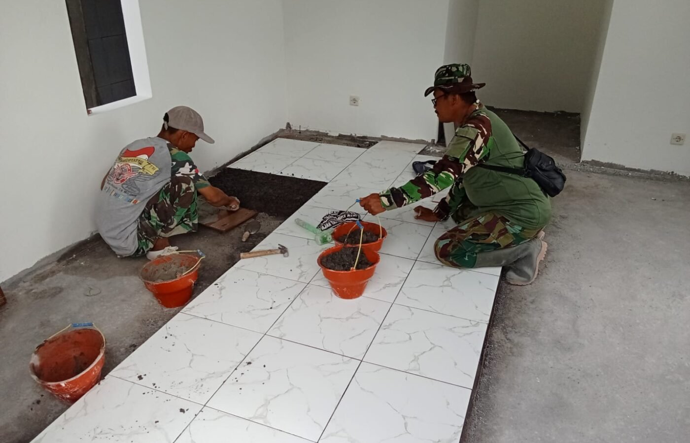 Proses Finishing Dimulai, Satgas TMMD Kodim 0813/Bojonegoro Laksanakan Pemasangan Keramik di Musala dan MCK