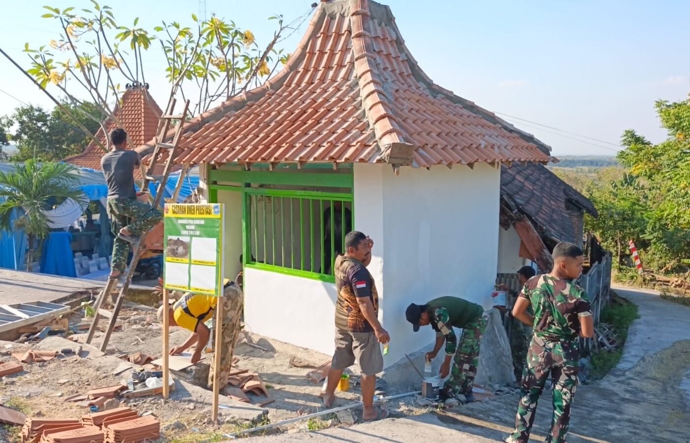 Kreativitas Anggota Satgas TMMD 129 Kodim 0812/Lamongan Hiasi Dinding Pos Kamling di Desa Tlemang