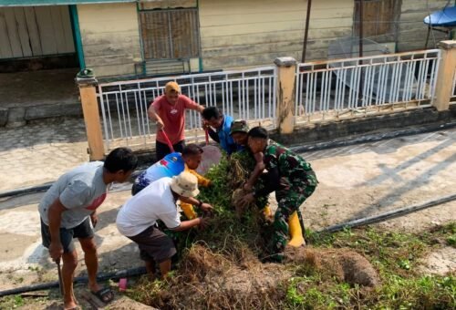 Kebersamaan Satgas TMMD dan Warga Dalam Membersihkan Lingkungan Desa Umbele