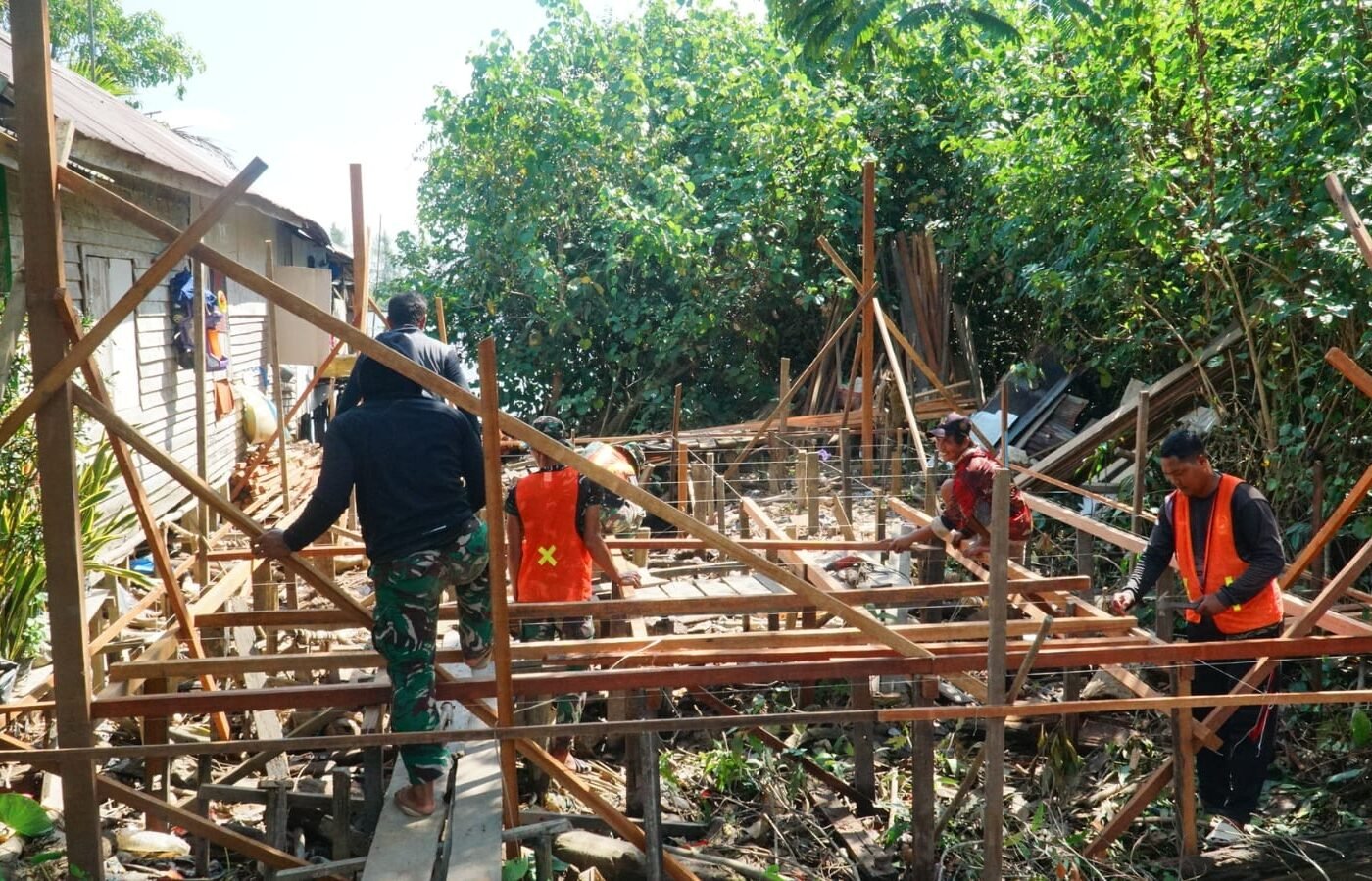 Kebersamaan Satgas TMMD Ke-129 dan Masyarakat dalam Pemasangan Kerangka Lantai RTLH di Desa Bandar Raya