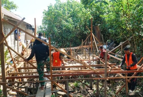 Kebersamaan Satgas TMMD Ke-129 dan Masyarakat dalam Pemasangan Kerangka Lantai RTLH di Desa Bandar Raya