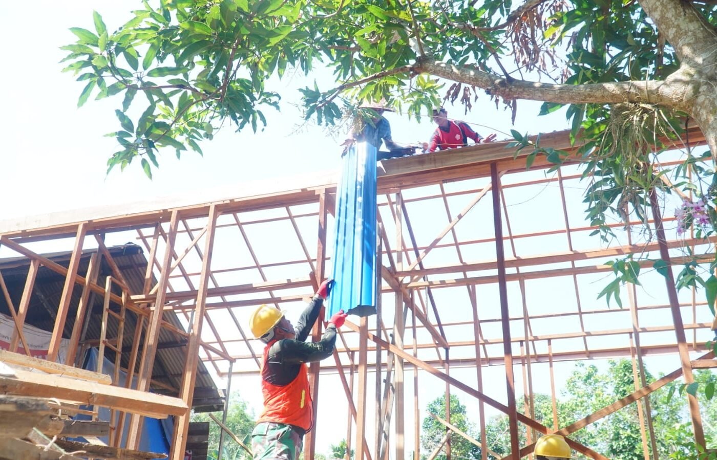 Kerja Sama Anggota TMMD dan Masyarakat dalam Pemasangan Atap RTLH