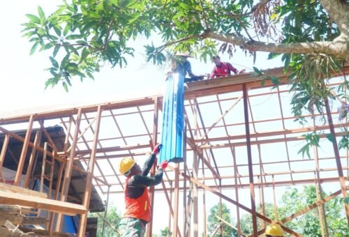 Kerja Sama Anggota TMMD dan Masyarakat dalam Pemasangan Atap RTLH